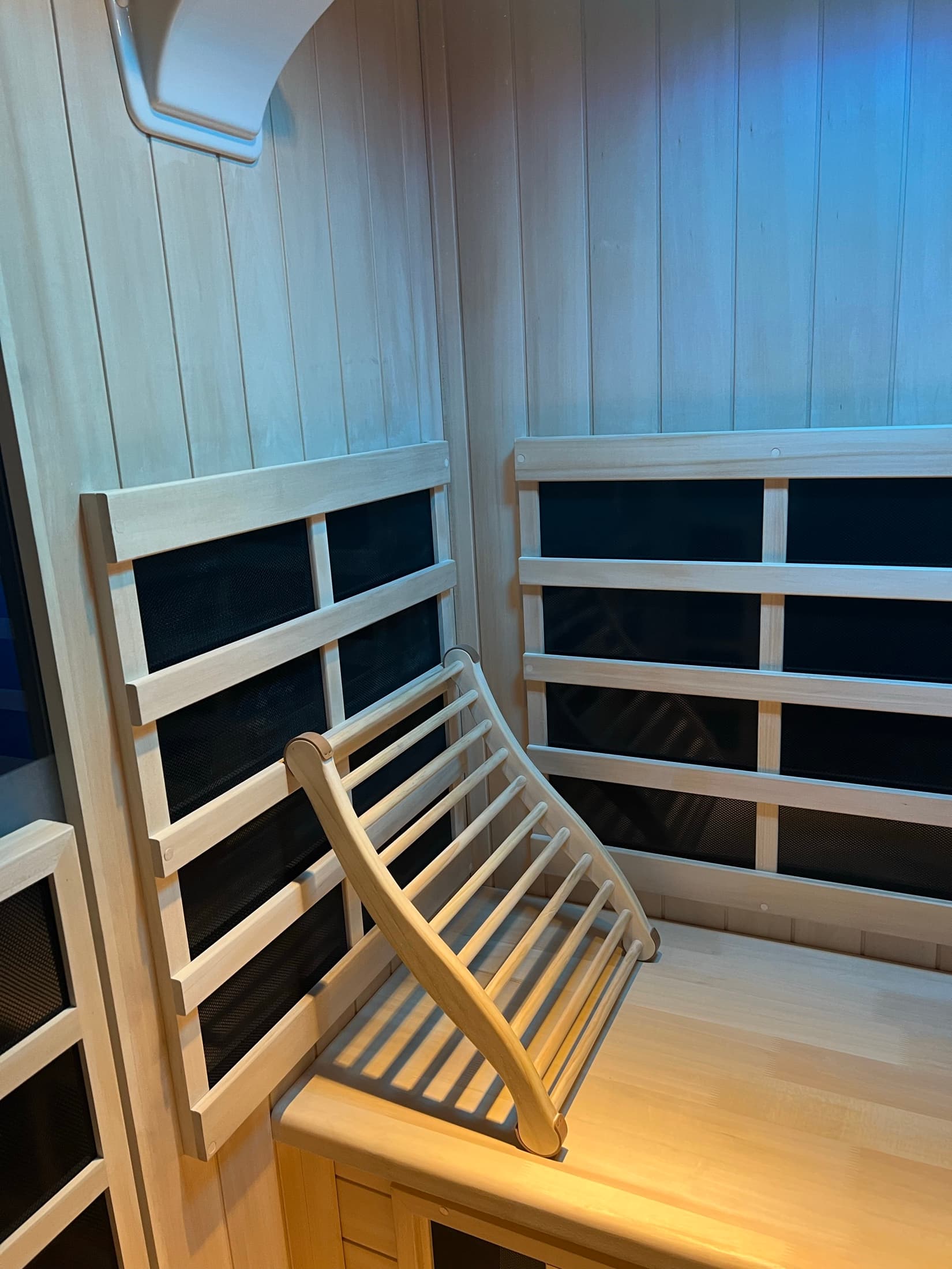 Guest seated comfortably in the infrared halotherapy room under a soft pink glow.
