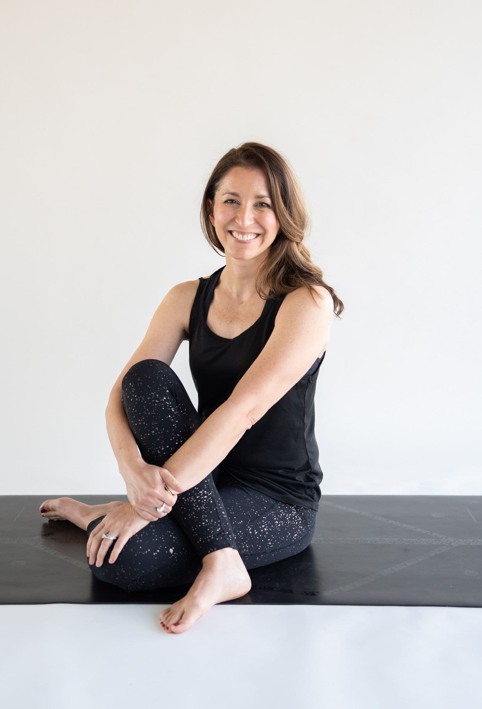 Yoga student seated on a mat, smiling