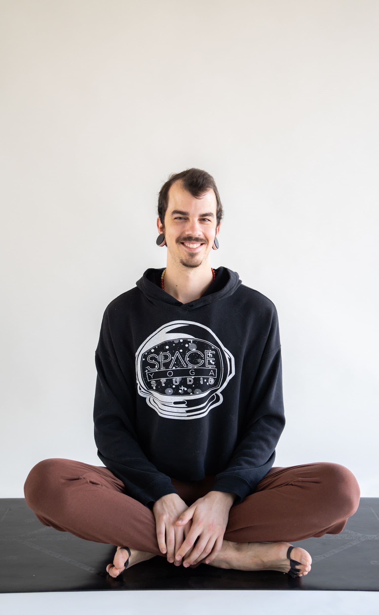 Yoga student seated cross-legged in studio gear