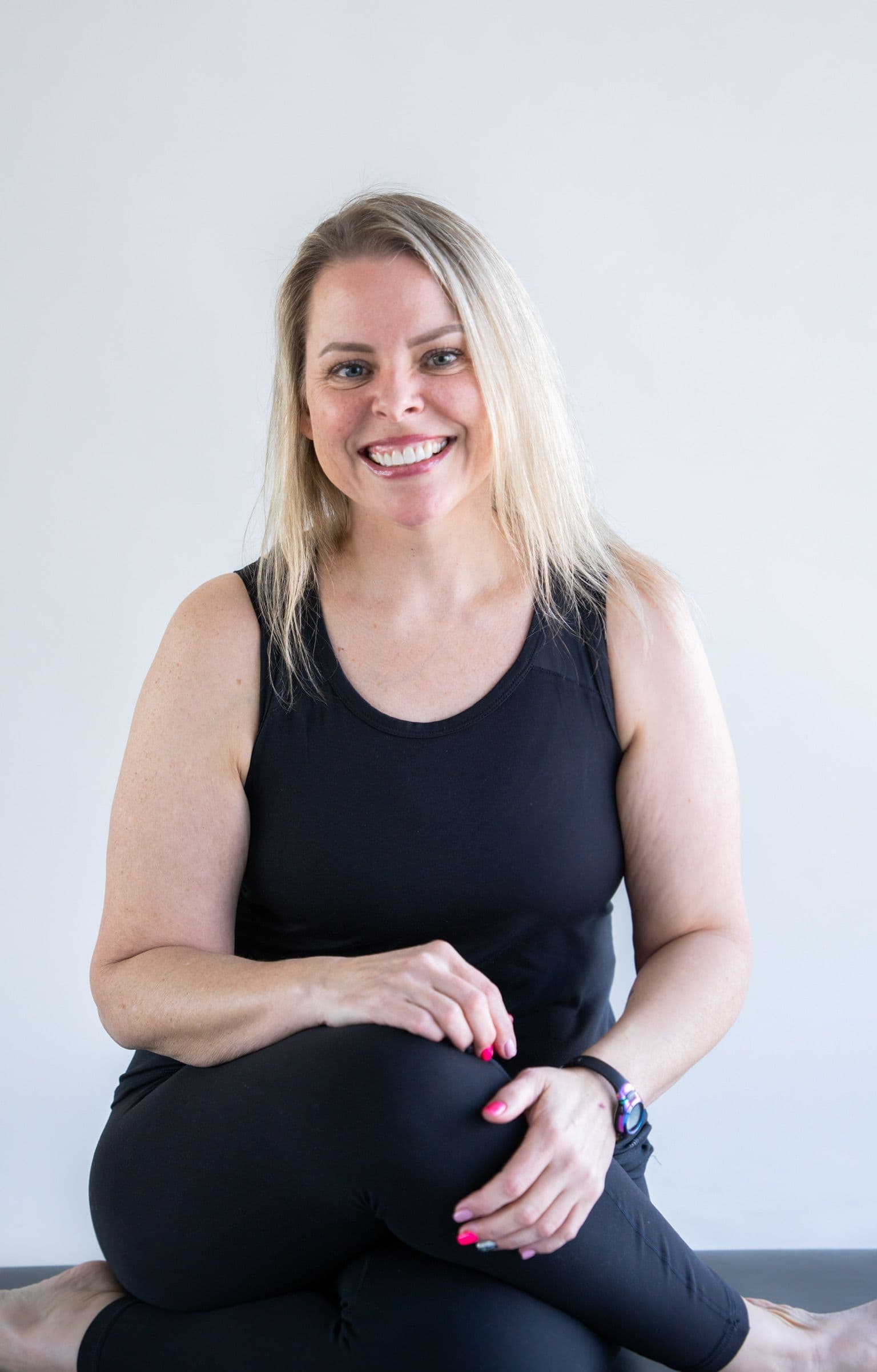 Yoga student seated on a mat, relaxed and smiling